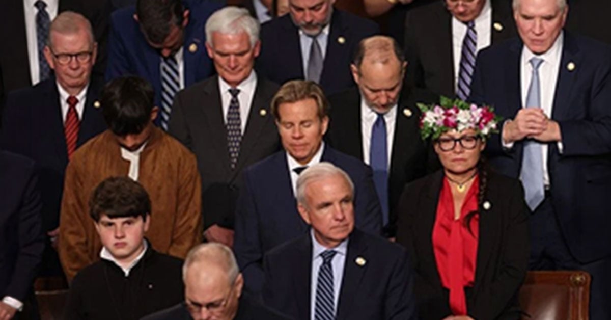 Members of Congress standing with heads bowed